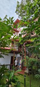 two people standing in front of a house at Ella Mount View Guest Inn in Ella