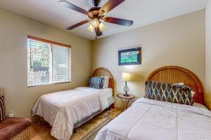 een slaapkamer met twee bedden en een plafondventilator bij Calle Quito Escape Permit# 217,228 in La Quinta +51 foto's