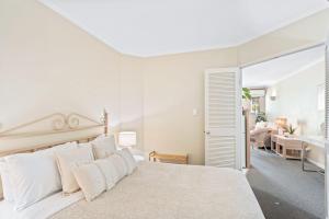 a white bedroom with a large bed with white pillows at Stylish CBD retreat - 8 Il Palazzo in Cairns +19 photos
