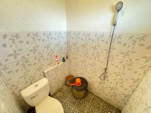 a bathroom with a toilet and a shower at Joglo Bandulan Homestay Jogja in Ngemplak +9 photos