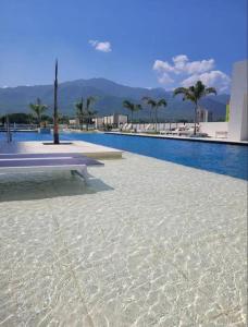 a swimming pool with a bench next to a building at Apartamento con diseño exclusivo, vista al mar in Santa Marta