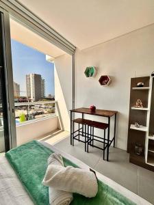 a bedroom with a bed and a table and a window at Apartamento con diseño exclusivo, vista al mar in Santa Marta