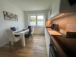 eine Küche mit Tisch und Stühlen und ein Esszimmer in der Unterkunft Haus Emma Großes Ferienhaus mit Garten für bis zu 10 Personen in Klosterdorf
