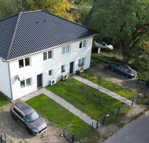 ein weißes Haus mit einem davor geparkten Auto in der Unterkunft Haus Emma Großes Ferienhaus mit Garten für bis zu 10 Personen in Klosterdorf