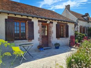 a brick house with a patio and a table and chairs at Charmante suite Volière au RDC, parking privé - FR-1-590-470 in Bonnée