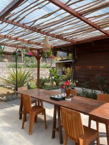 a wooden patio table and chairs under a wooden pergola at Woody House in Bedugul +12 photos