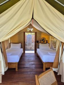 Giường trong phòng chung tại Desa Air Hot Springs & Glamping