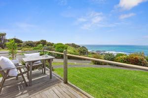 a wooden deck with a table and chairs and the ocean at 2 Whitecrest Great Ocean Road Resort - Ocean Views in Wongarra