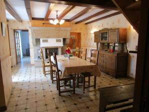 a kitchen with a table and chairs and a fireplace at Maison familiale avec cheminée, jardin et WiFi à Esley, Vosges - FR-1-589-743 in Esley