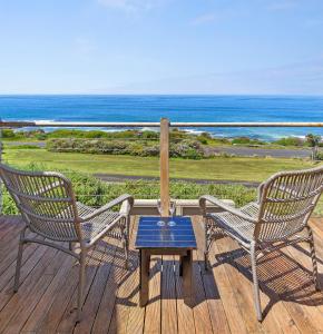 two chairs and a table on a deck with the ocean at 13 Whitecrest Great Ocean Road Resort - Ocean Views in Wongarra
