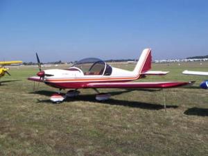 un piccolo aereo rosso e bianco seduto sull'erba di Ferme rénovée au calme - 4 chambres, petit-déjeuner inclu - FR-1-590-450 a Cravant Altre 2 foto