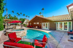 een huis met een zwembad met rode stoelen bij Calle Quito Escape Permit# 217,228 in La Quinta