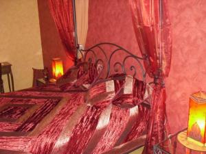 a bedroom with a red bed with red curtains at Maison charmante avec 4 chambres thématiques au cœur du pays de Jeanne d'Arc - FR-1-585-149 in Montigny-lès-Vaucouleurs