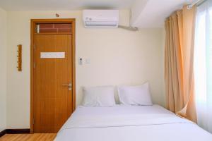 Un pat sau paturi într-o cameră la Comfortable and Tidy 2BR at Cinere Resort Apartment By Travelio +13 fotografii