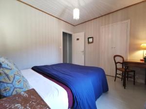 a bedroom with a bed and a table and a desk at Maison de campagne paisible avec terrasse et animaux admis - FR-1-582-505 in Sembadel