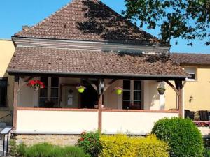 a house with a large window and a roof at Chambres avec petit-déjeuner et table d'hôtes près des Châteaux de la Loire - FR-1-591-698 in Fontguenand