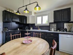 a kitchen with a wooden table in a kitchen at Chambre Verte avec Jardin partagé près du Puy-en-Velay - FR-1-582-498 in Rosières