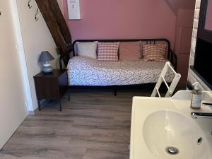 ein Badezimmer mit Waschbecken und ein Bett in einem Zimmer in der Unterkunft Chambres d'hôtes proche Valençay avec petit déjeuner inclus et parking - FR-1-591-698 in Fontguenand
