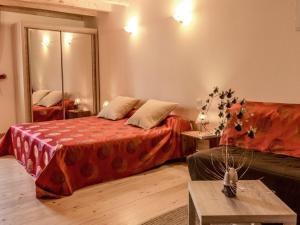 a bedroom with a bed and a couch and a table at Chambre Rubis: Élégance et Confort en Pleine Nature - FR-1-589-723 in Le Clerjus