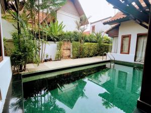 a swimming pool in front of a house at Bali Style Luxury 400sqm Semi-4BED POOL VILLA near Beach & Walking Street in Jomtien Beach +244 photos