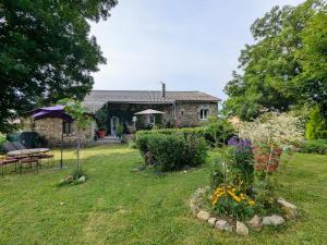 a yard with a stone house with a garden at Maison d'hôtes rénovée avec table d'hôte dans la campagne Altiligérienne - FR-1-582-522 in Saint-Victor-sur-Arlanc