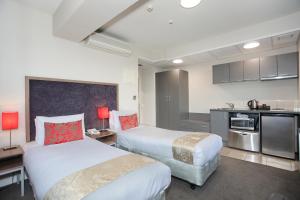 a hotel room with two beds and a kitchen at Ramada Encore by Wyndham Palmerston North in Palmerston North +48 photos