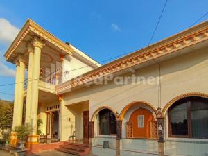 a building with columns and a balcony on it at Orange inn RedPartner Madiun in Madiun