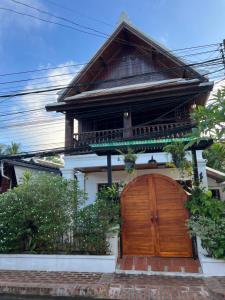 a house with a wooden door in front of it at Xiengthong Villa in Luang Prabang