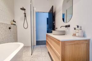 a bathroom with a sink and a tub and a mirror at Peters Rest Central Wagga in Wagga Wagga +28 photos