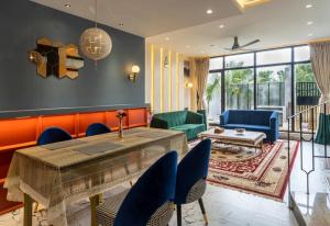 a living room with a table and blue chairs at Hina Manzil in Yelagiri