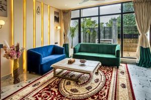 a living room with two blue couches and a table at Hina Manzil in Yelagiri