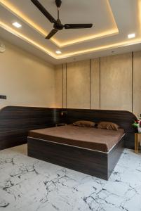 a bedroom with a large bed and a ceiling fan at Hina Manzil in Yelagiri