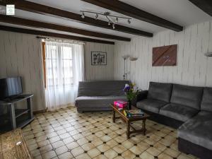 a living room with a couch and a table at Maison familiale avec cheminée, jardin et WiFi à Esley, Vosges - FR-1-589-743 in Esley