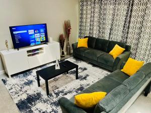 - un salon avec un canapé vert et une télévision dans l'établissement House 3-Bed 2,5-Bath FREE Parking with Washer Dryer inside, à The Woodlands