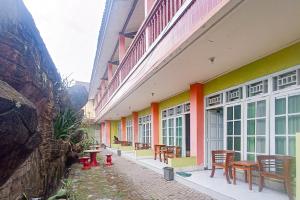 une rangée de chaises et de tables à l'extérieur d'un bâtiment dans l'établissement Hotel Dienda Hayu, à Lombok