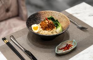 a bowl of noodles and an egg on a table at Moonlit Suites in Hanoi +64 photos