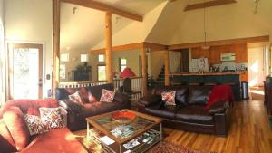 Una sala de estar con sofás de cuero y una mesa. en Creekside Craftsman Cabin with Jacuzzi - Alpine Splendor 6 Mins to downtown, en Boulder