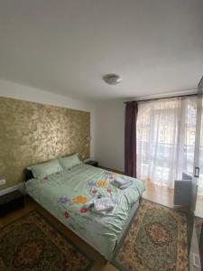 a bedroom with a bed with a rug and a window at Casa Cristalina&Dumi in Albac
