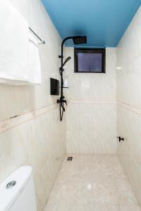 a bathroom with a toilet and a tv on the wall at Air Residence 10978 in Hulhumale