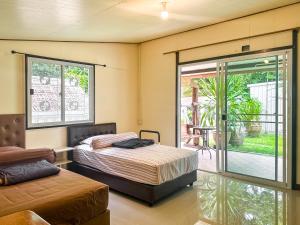 een slaapkamer met een bed en een glazen schuifdeur bij Baan Panmala Guesthouse - Ao Luek, Krabi in Krabi town