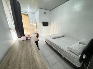 a bedroom with a bed and a table in it at Omah Sinduadi Homestay Jogja in Kejayan