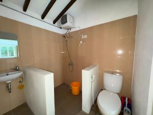 a bathroom with a toilet and a sink at Omah Sinduadi Homestay Jogja in Kejayan +17 photos