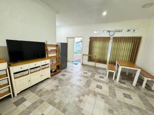 a living room with a flat screen tv and a table at Omah Sinduadi Homestay Jogja in Kejayan