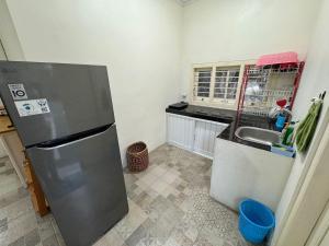 a kitchen with a refrigerator and a sink at Omah Sinduadi Homestay Jogja in Kejayan