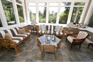 a living room with couches and tables and windows at Clyde Hall Bed and Breakfast in Lanark