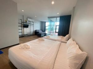 a bedroom with two beds and a living room at Lamoon Trang in Ban Phlu Phli
