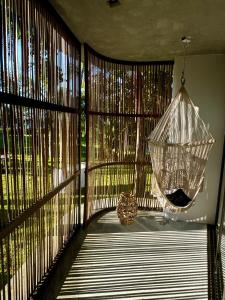 a porch with a hammock hanging from a window at Villa Turquesa - Home in Morro de São Paulo