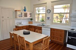 a kitchen with a table and chairs in it at Yia Yias Place - Bring your own linen. in South West Rocks