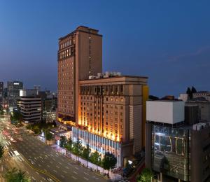 ソウルにあるGrand Mercure Imperial Palace Seoul Gangnamの街中の明かりが灯っている高層ビル