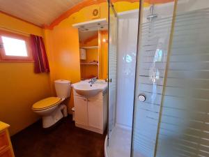 un bagno con wc, lavandino e doccia di Roulotte Esméralda: Séjour insolite au cœur de la nature, climatisée, parking privé, prêt de vélos - FR-1-590-502 a Bonnée